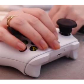Close-up of hands using a gaming controller with a focus on the control layout.