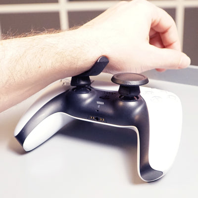Person using a gaming controller with Thumb Soldiers Rest kit on a white background